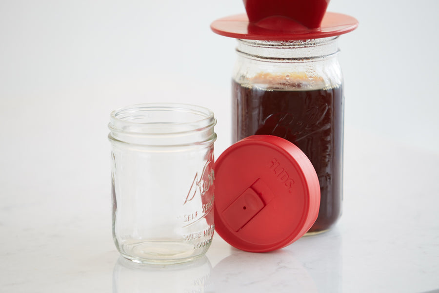 Pour-over coffee in a mason jar next to an iLids drink lid