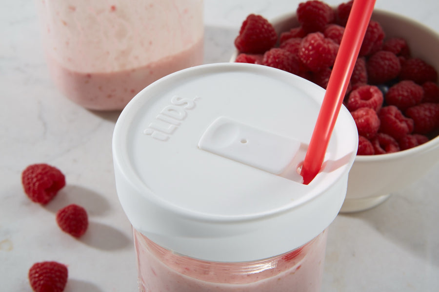 Raspberry smoothie in a mason jar with an iLids drink lid and straw